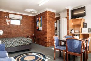 a living room filled with furniture and a fireplace at Country Pathfinder Motor Inn in Dalby