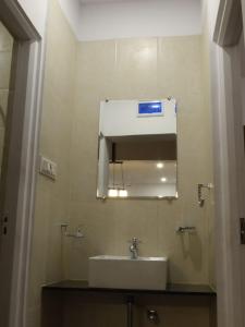 ein Bad mit einem Waschbecken und einem Spiegel in der Unterkunft Nostalgia Villas in Silāri