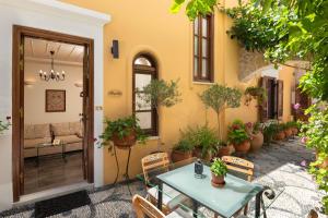an outdoor patio with a table and chairs and potted plants at Rodos Niohori Elite Suites Boutique Hotel in Rhodes Town