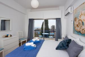 a bedroom with a bed with blue sheets and a balcony at White Arches Apt #1 by TrulyCyprus in Limassol