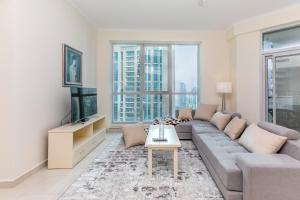 a living room with a couch and a tv at 2BR High Floor Torch Tower Dubai Marina in Dubai