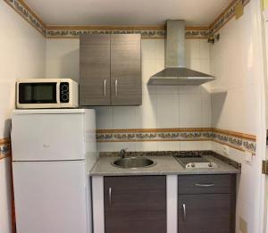eine kleine Küche mit einem weißen Kühlschrank und einer Spüle in der Unterkunft benalbeach, 315 in Benalmádena