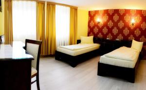 a hotel room with two beds and a table at Pensiunea Junior in Cluj-Napoca