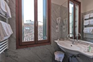 ein Badezimmer mit einem Waschbecken und einem großen Fenster in der Unterkunft Palazzo Cendon Piano Antico in Venedig