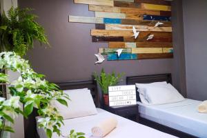 a bedroom with two beds and a wooden wall at Hostel Privado in Puerto Princesa City +27 photos