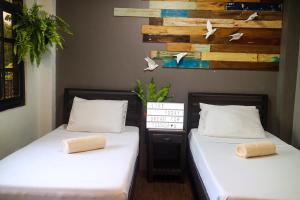 two beds sitting next to each other in a room at Hostel Privado in Puerto Princesa City