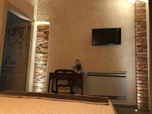 a bedroom with a bed and a television on the wall at Villa Laura in Castellinaldo