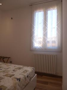 sypialnia z łóżkiem i oknem w obiekcie Giudei House Minisuite w Bolonii