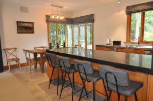 una cucina con bar, tavolo e sedie di BOND ESTATE LUXURY ACCOMMODATION a Christchurch
