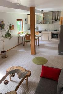 a living room with a table and a kitchen at Gemütliche Ferienwohnung in ländlicher Idylle in Vöhl