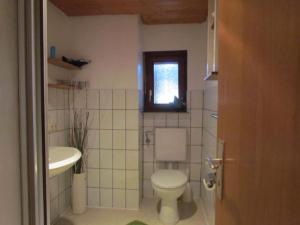 La salle de bains est pourvue de toilettes, d'un lavabo et d'une fenêtre. dans l'établissement Gemütliche Ferienwohnung in ländlicher Idylle, à Vöhl