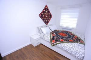 een kleine slaapkamer met een bed en een raam bij Overlooking Registan Square Luxury 2 Bedrooms Apartment in Samarkand