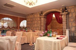 a restaurant with tables with white table cloths and wine bottles at Villa Carmela in Sessa Aurunca