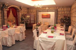 a banquet room with white tables and chairs with flowers at Villa Carmela in Sessa Aurunca +17 photos
