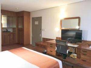 a bedroom with a bed and a desk and a television at Holiday Inn & Suites Port Moresby, an IHG Hotel in Port Moresby