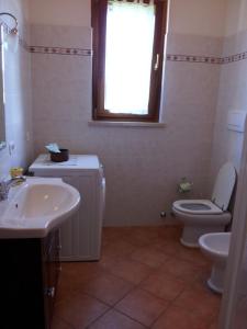 a bathroom with a sink and a toilet and a window at Agriturismo Le Giunchiglie in Alberese