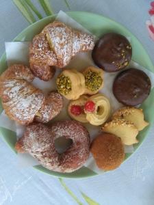 a plate of donuts and other pastries on a table at La Castellese in Aci Castello