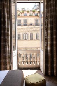 a bedroom with a large window with a view of a building at Le Quattro Dame Luxury Suites in Rome