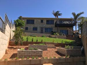 a house with a garden in front of it at Sandy Bottoms in Jeffreys Bay