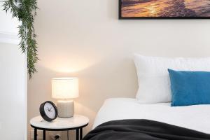 a bedroom with a bed and a clock on a table at Amazing River View - 3 Bedroom Apartment - Brisbane CBD - Netflix - Fast Wifi - Carpark in Brisbane