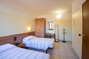 una camera d'albergo con due letti e un tavolo di Hotel Fattori a Bologna
