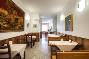 un restaurant avec des tables et des chaises et une peinture murale. dans l'établissement Hotel Fattori, à Bologne