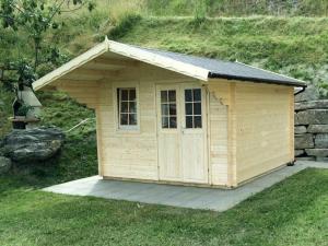 a small wooden shed sitting in the grass at Bual da Rumein Wettstein - Ferienhaus 110m2 für max. 6 Pers. in Degen