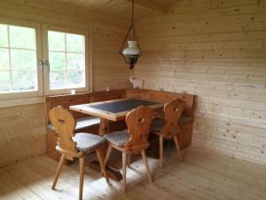 a wooden dining room with a table and two chairs at Bual da Rumein Wettstein - Ferienhaus 110m2 für max. 6 Pers. in Degen