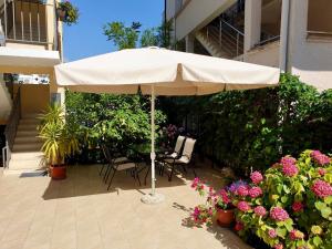 una sombrilla blanca sentada en un patio con flores en Villa Rihter en Budva