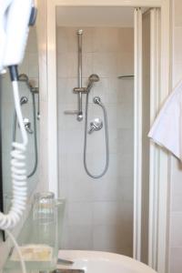 uma casa de banho com um chuveiro e um lavatório. em Hotel Lido em Vasto