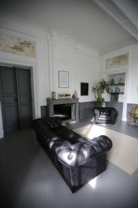 a leather couch in a living room with a fireplace at Chateau Saint Martin B&B in Pouillon