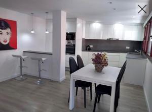 eine weiße Küche mit einem weißen Tisch und Stühlen in der Unterkunft Apartamento totalmente reformado en 1ª linea in Palamós