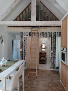 a loft bed in a kitchen with a table and a ladder at logement en campagne in Landemer