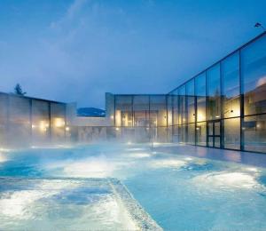 una piscina de agua frente a un edificio en Charmant Petit Chalet 3 étoiles en Gruyère en Crésuz