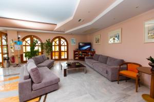 a living room with two couches and a tv at Anita Beach Hotel- Adults Only in Rethymno