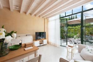 een woonkamer met een bank en een tafel met een tv bij Rambaldi Apartments Casa nr 4 Garden in Bardolino