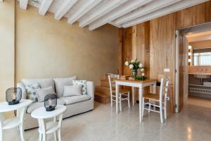 een woonkamer met een bank en een tafel en stoelen bij Rambaldi Apartments Casa nr 4 Garden in Bardolino