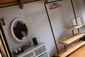 a room with a mirror and a shelf on a wall at Tidimalo Lodge in Rustenburg