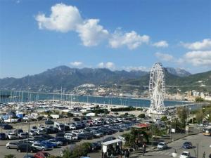 ein Parkplatz mit einem Riesenrad im Hintergrund in der Unterkunft SOLIDEA BNB in Salerno