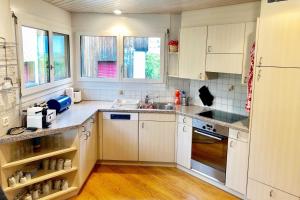 a kitchen with white cabinets and a sink at Haus Alpenblick A5 - CharmingStay in Flumserberg +7 photos