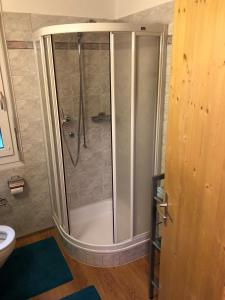 a shower with a glass door in a bathroom at Haus Alpenblick A5 - CharmingStay in Flumserberg