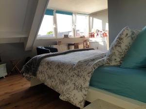 una camera da letto con un letto con una coperta e due finestre di B&B 't Merthoes a Susteren
