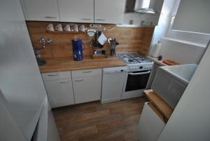 a small kitchen with white cabinets and a stove at Haus Rehblick FeWo-App-2 in Sankt Andreasberg