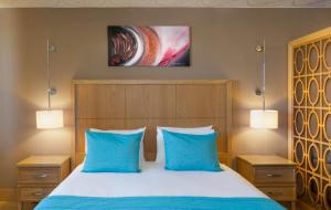 una camera con un letto con due cuscini blu di Hotel Setif Plus a Sétif