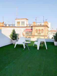 dos sillas blancas y una mesa en el techo en GoToSeville FERIA APARTMENTS, en Sevilla