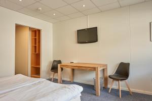 a bedroom with a desk and a tv on the wall at BB-Hotel Herning "Messehotel" in Herning