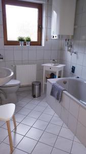 ein Badezimmer mit Badewanne, Toilette und Waschbecken in der Unterkunft Nähe Mainz - Ferienwohnung - Apartment Breivogel in Wörrstadt in Wörrstadt + 21 Fotos