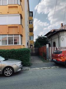two cars parked in front of a building at Lala's Home in Ploieşti