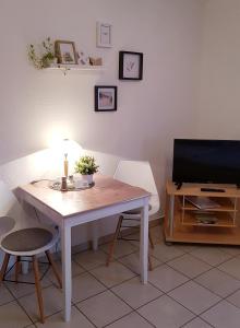 ein Wohnzimmer mit Tisch und Fernseher in der Unterkunft Nähe Mainz - Ferienwohnung - Apartment Breivogel in Wörrstadt in Wörrstadt