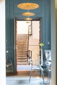 een eetkamer met een glazen tafel en een trap bij Le Quattro Dame Luxury Suites in Rome